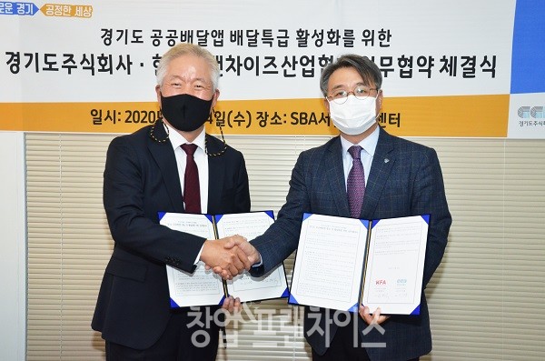 정현식 한국프랜차이즈산업협회장과 이석훈 경기도주식회사 대표가 협약서 서명 후 기념 촬영을 하고 있다.