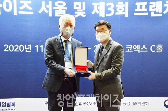 지난해 최고의 FC기업가로 협회장 표창을 수상한 (주)장스푸드(60계) 임영태 부사장(오른쪽)과 정현식 한국프랜차이즈산업협회장(왼쪽)