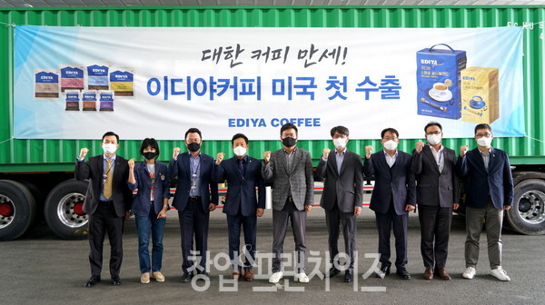 26일 이디야커피 문창기 회장(왼쪽에서 다섯 번째)을 비롯한 관계자들이 미국 수출용 제품을 담은 컨테이너 앞에서 기념촬영을 하고 있다.